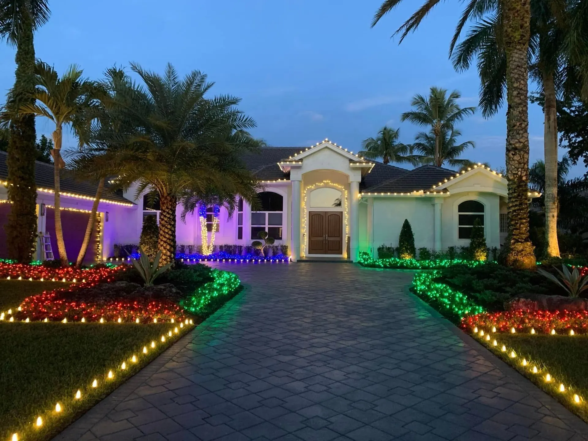 Driveway lined with multicolor Christmas lights
